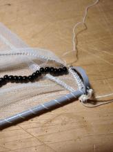 Uchycení sítě na druhé straně ráhna a k obruči